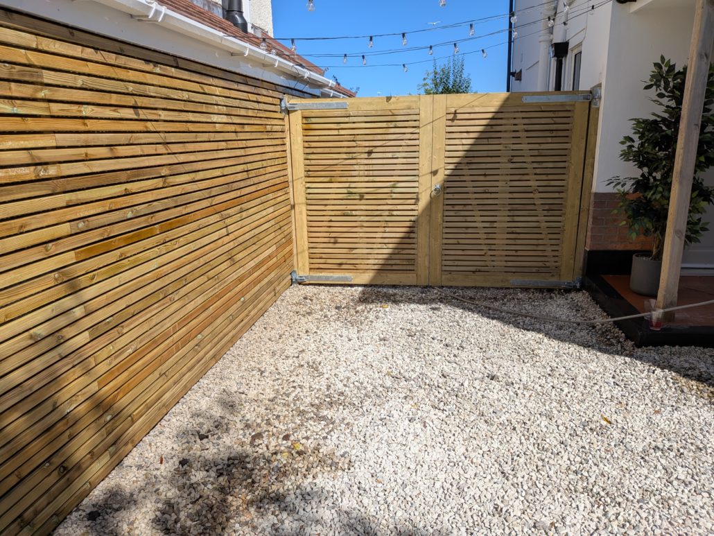 After photo of completed Fencing in Queens Park: Contemporary Slatted Driveway Gates and Parking Widening in Queens Park. - After