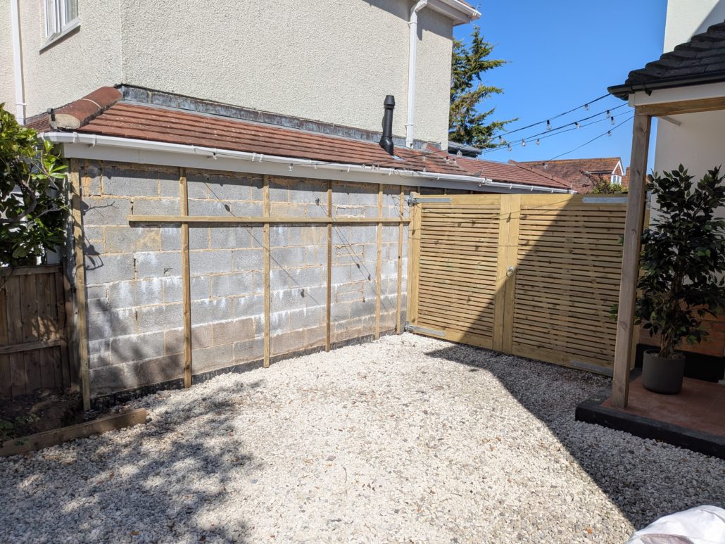 After photo of completed Fencing in Queens Park: Contemporary Slatted Driveway Gates and Parking Widening in Queens Park. - Gallery